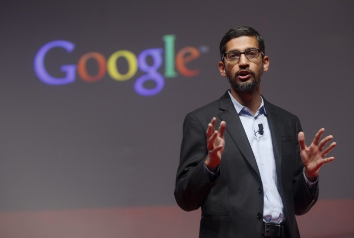 Google CEO Sundar Pichai stands with Apple