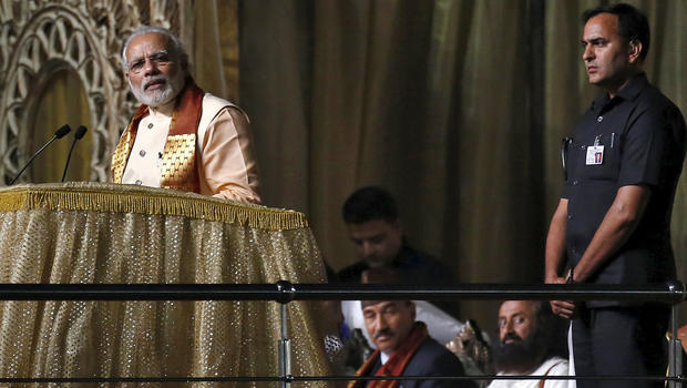 India's Prime Minister Narendra Modi addresses guru Sri Sri Ravishankar's World Culture Festival on the banks of the Yamuna River in New Delhi, India, March 11, 2016. Ravishankar can be seen seated, at right, behind Modi. Reuters