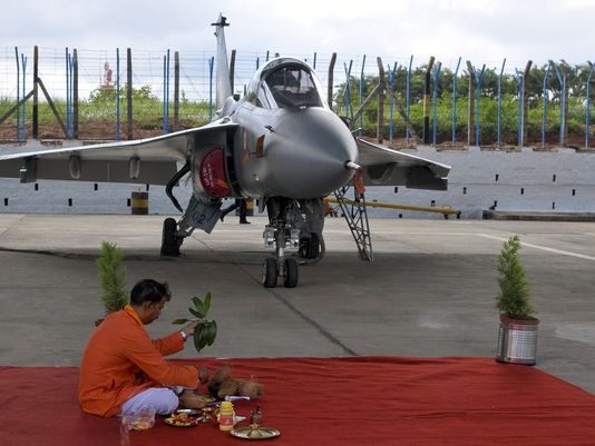 An Indian Hindu priest conducts a ritual in front of a newly commissioned Indian Air Force (IAF) Tejas or Light Combat Aircraft (LCA) in Bangalore on July 1, 2016, during a ceremony in the southern Indian city. (Photo: STR, AFP/Getty Images)