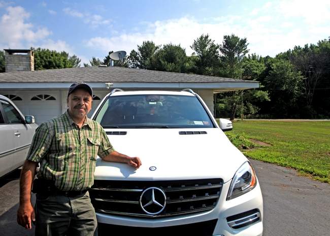 Surjeet Bassi stands next to his Mercedes-Benz at his home in Middletown. Bassi has filed a $1.26 million lawsuit against Prestige Motors Inc. in Bergen County, N.J., over a June 3 incident at the dealership.