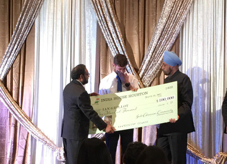 Ian Grillot gets emotional as he accepts a check from Indian Ambassador Navtej Sarna