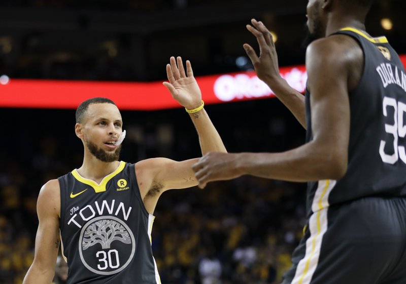 Golden State Warriors guard Stephen Curry (30) celebrates with forward Kevin Durant during the first half of Game 2 of basketball’s NBA Finals against the Cleveland Cavaliers in Oakland, Calif., Sunday, June 3, 2018. (AP Photo/Marcio Jose Sanchez)